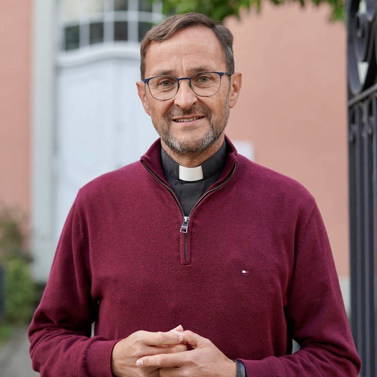 Pfarrer Jörg Meyrer ist Seelsorger im Ahrtal in RLP. Er trägt einen weinroten Pullover und sieht ernst in die Kamera. In SWR1 Leute spricht er über die Folgen der Flut für die Menschen. (Foto: Bonifatius Verlag)