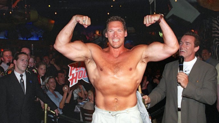 Ralf Moeller zeigt am 24.5.1999 in Anwesenheit seines Schauspielerkollegen und Freundes Arnold Schwarzenegger (r.) im Münchner Restaurant "Planet Hollywood" seine Muskeln.