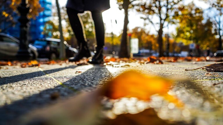 Herbstliche und sonnige Atmosphäre. Eine schlanke dunkle Gestalt läuft am Kurfürstendam (Foto: IMAGO, Stefan Zeitz)