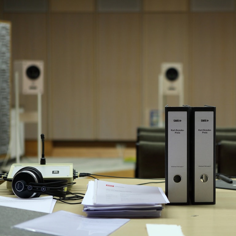Tisch mit zwei Aktenordnern und drei Lausprechern im Hintergrund (Foto: SWR, Frank Halbig)