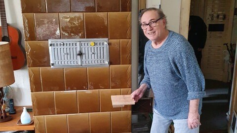 Foto: Thomas Kruchem Guillermo Frei mit Palettenholz und Kachelofen: Der Berliner Rentner verfeuert Holz, das er auf der Straße findet. Denn in Berlin ist Brennholz knapp und teuer. Lackiertes und geöltes Holz sei für ihn tabu, sagt Frei: "Weil das Gift ist. Ich will doch nicht meinen Nachbar vergiften. Und mich selber." (Foto: Thomas Kruchem)