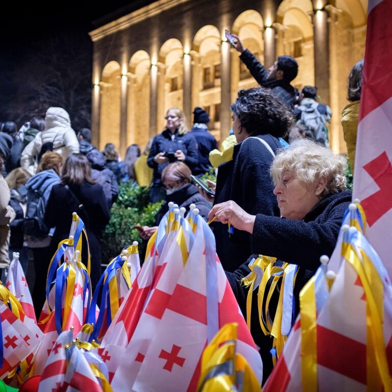 In Tiflis  Georgien verkauft eine Frau bei der Demonstration am 28. Februar 2022 gegen die russische Invasion in der Ukraine georgische Flaggen, die mit Bändern in den Farben der ukrainischen Flagge geschmückt sind. Seit 2008 besetzt Russland Teile Georgiens. Im Frühjahr 2023 demonstrierten die Georgier gegen ihre prorussische Regierung. Der russische Angriffskrieg gegen die Ukraine entscheidet auch über ihre Zukunft. (Foto: IMAGO, IMAGO / ZUMA Wire)