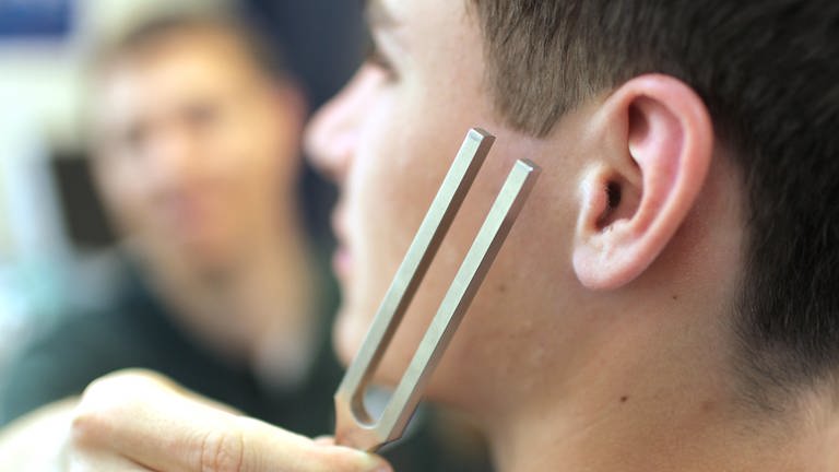 Symbolbild: Ein Jugendlicher wird beim Hals-Nasen-Ohrenarzt mit einer Stimmgabel untersucht. (Foto: picture-alliance / Reportdienste, picture alliance / Caro | Seeberg)