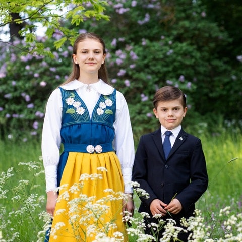 Prinzessin Estelle und Prinz Oscar posieren in traditioneller Tracht und Anzug auf einer grünen Wiese für den schwedischen Nationalfeiertag. (Foto: Pressestelle, Sara Friberg/The Royal Court of Sweden) Prinzessin Estelle und Prinz Oscar posieren in traditioneller Tracht und Anzug auf einer grünen Wiese für den schwedischen Nationalfeiertag.