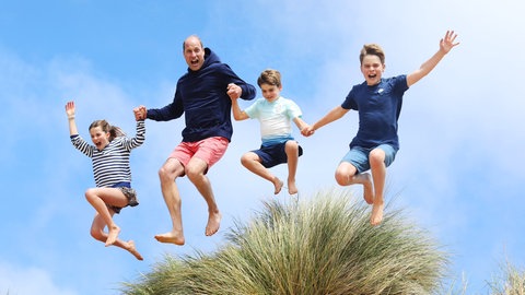 Zum 42. Geburtstag von Prinz William veröffentlich das britische Königshaus ein Foto des Thronfolgers mit seinen Kindern Prinz George, Prinzessin Charlotte and Prinz Louis, wie sie von einen Dühne springen. (Foto: picture-alliance / Reportdienste, picture alliance / empics | Princess of Wales/Kensington Palace) Zum 42. Geburtstag von Prinz William veröffentlich das britische Königshaus ein Foto des Thronfolgers mit seinen Kindern Prinz George, Prinzessin Charlotte and Prinz Louis, wie sie von einen Dühne springen.