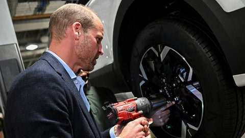 Prinz William montiert mit einem elektrischen Schraubenschlüssel einen Autoreifen. (Foto: IMAGO, Chris Ratcliffe) Prinz William montiert mit einem elektrischen Schraubenschlüssel einen Autoreifen.