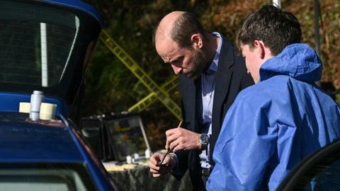 Prinz William steht an einem Auto und sucht mit Puder und Pinsel an einem gestellten Tatort nach Fingerabdrücken. Der britische Thronfolger besuchte ein College in Südengland und ließ sich von Studenten die Arbeitsweise der Kriminaltechnik zeigen. (Foto: picture-alliance / Reportdienste, picture alliance / Photoshot) Prinz William steht an einem Auto und sucht mit Puder und Pinsel an einem gestellten Tatort nach Fingerabdrücken. Der britische Thronfolger besuchte ein College in Südengland und ließ sich von Studenten die Arbeitsweise der Kriminaltechnik zeigen.