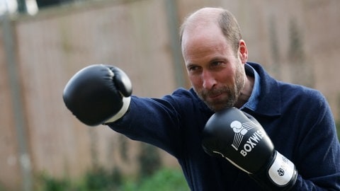 Prinz William trägt Boxhandschuhe und boxt damit konzentriert in die Luft. Er trägt eine dunkelblaue Jacke dazu. (Foto: picture-alliance / Reportdienste, picture alliance/dpa/PA Wire | Hannah Mckay) Prinz William trägt Boxhandschuhe und boxt damit konzentriert in die Luft. Er trägt eine dunkelblaue Jacke dazu.