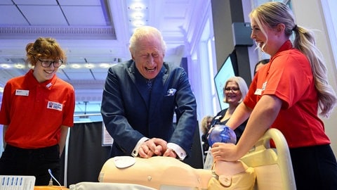 Kleiner royaler Erste-Hilfe-Kurs: Der britische König Charles III. führt eine Herz-Lungen-Wiederbelebung an einer medizinischen Testpuppe durch, als er an einer Feier für den 1.000sten RCN King's Nursing Cadet im Royal College of Nursing in London teilnimmt. (Foto: dpa Bildfunk, Picture Alliance) Kleiner royaler Erste-Hilfe-Kurs: Der britische König Charles III. führt eine Herz-Lungen-Wiederbelebung an einer medizinischen Testpuppe durch, als er an einer Feier für den 1.000sten RCN King's Nursing Cadet im Royal College of Nursing in London teilnimmt.