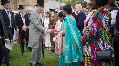 König Charles begrüßt bei der ersten Gartenparty des Jahres Gäste. (Foto: dpa Bildfunk, dpa/PA Wire | Yui Mok) König Charles begrüßt bei der ersten Gartenparty des Jahres Gäste.