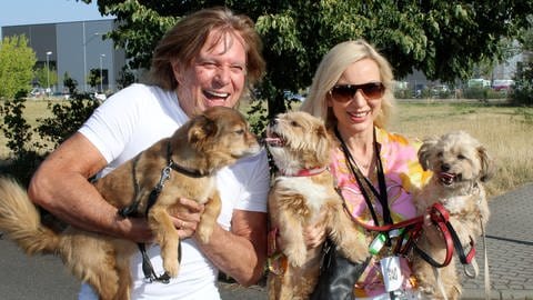 Schlagerstar Jürgen Drews ("Ein Bett im Kornfeld") und seine Frau Ramona haben Spaß mit drei Hunden auf dem Arm