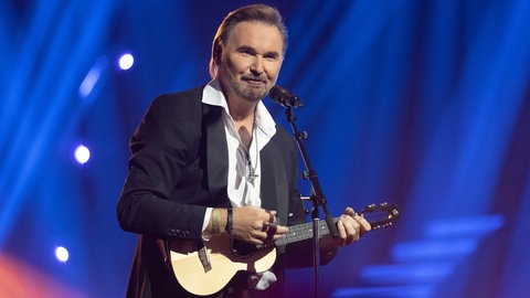 Schlagersänger Nik P. steht auf der Bühne und spielt eine Ukulele. (Foto: picture-alliance / Reportdienste, picture alliance / ZDF/Sascha Baumann | Sascha Baumann) Schlagersänger Nik P. steht auf der Bühne und spielt eine Ukulele.