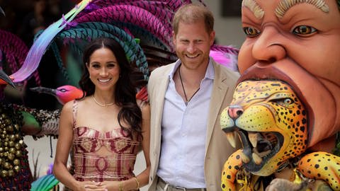 Prinz Harry und Herzogin Meghan zu Besuch in Kolumbien. Neben ihnen sind zwei Masken des Kunstzentrums "Zapata". (Foto: picture-alliance / Reportdienste, picture alliance/dpa/AP | Ivan Valencia) Prinz Harry und Herzogin Meghan zu Besuch in Kolumbien. Neben ihnen sind zwei Masken des Kunstzentrums "Zapata".