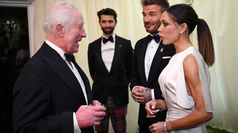 König Charles empfängt in schwarzer Abendgarderobe den ehemaligen Fußballstar David Beckham im schwarzen Smoking und seine Frau Victoria Beckham im schwarzen Kleid. (Foto: picture-alliance / Reportdienste, picture alliance/dpa/PA Wire | Finnbarr Webster) König Charles empfängt in schwarzer Abendgarderobe den ehemaligen Fußballstar David Beckham im schwarzen Smoking und seine Frau Victoria Beckham im schwarzen Kleid.