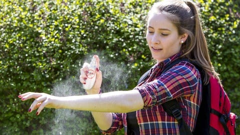Junge Frau trägt Mückenschutz auf - das Spray hilft auch gegen Grasmilben (Foto: IMAGO, Jochen Tack) Junge Frau trägt Mückenschutz auf - das Spray hilft auch gegen Grasmilben