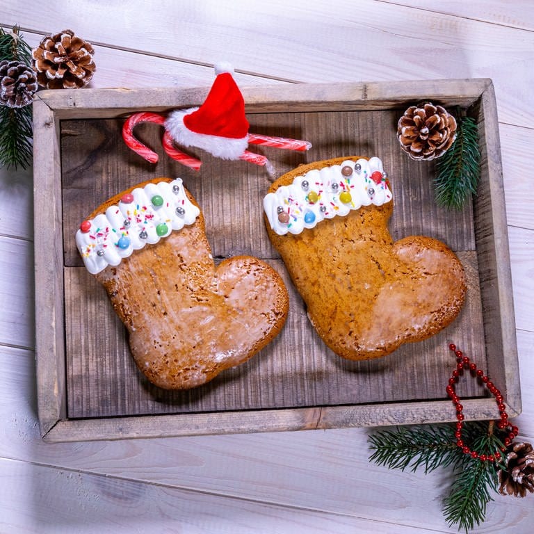 Nikolausstiefel backen: Die fertigen Nikolausstiefel sind schön angerichtet auf einem Holzbrett mit Tannenzweigen. (Foto: SWR, Corinna Holzer)