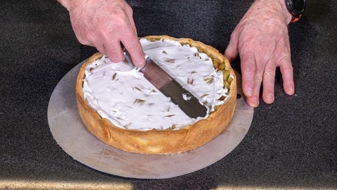 Nun kommt die Haube aus Baiser: Die Masse aus Zucker und Eischnee wird auf den Rhabarberkuchen gestrichen. (Foto: SWR, Corinna Holzer) Nun kommt die Haube aus Baiser: Die Masse aus Zucker und Eischnee wird auf den Rhabarberkuchen gestrichen.