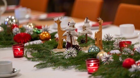 Festlich geschmückter Tisch mit Weihnachtsdeko und Kerzen. (Foto: picture-alliance / Reportdienste, picture alliance/dpa | Monika Skolimowska) Festlich geschmückter Tisch mit Weihnachtsdeko und Kerzen.