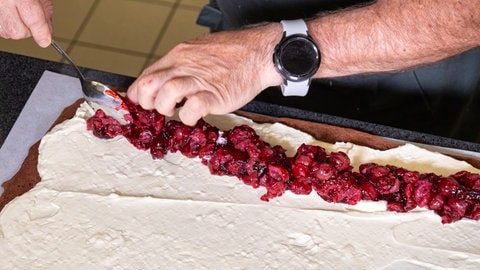 Rezept für Schwarzwälder Kirsch als Rolle: Die Kirschmasse wird auf der Sahne verteilt. (Foto: SWR, Corinna Holzer) Rezept für Schwarzwälder Kirsch als Rolle: Die Kirschmasse wird auf der Sahne verteilt.