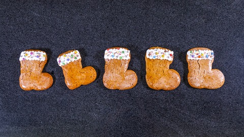 Nikolausstiefel backen: Fünf fertige Stiefelchen aufgereiht auf einem Tisch (Foto: SWR, Corinna Holzer) Nikolausstiefel backen: Fünf fertige Stiefelchen aufgereiht auf einem Tisch