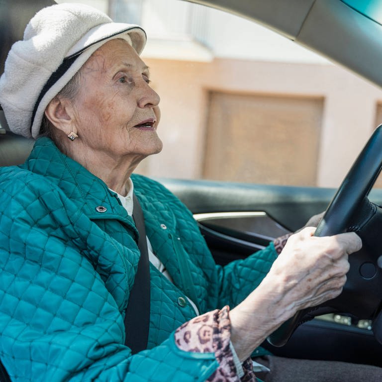 Senior woman driving car on road model released (Foto: IMAGO, Westend61)