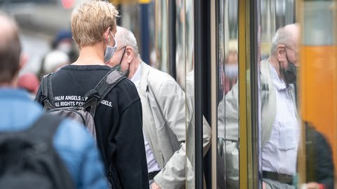 Passanten mit Mund- und Nasenschutz steigen in eine U-Bahn. (Foto: dpa Bildfunk, picture alliance/dpa | Sebastian Gollnow)