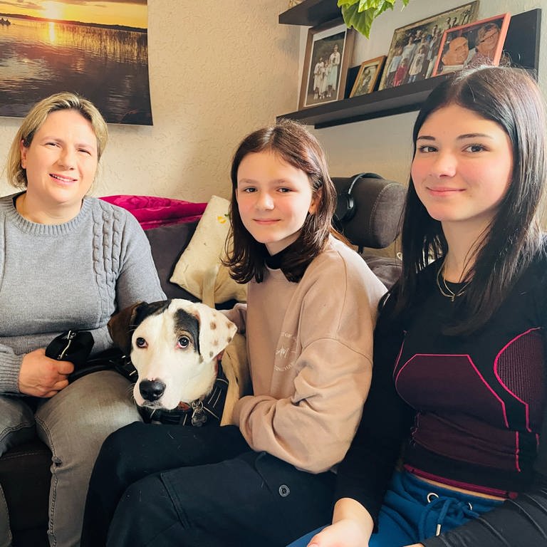 Mutter Kathrin Frick, Hund Mabu und ihre Töchter Anna und Lilly im gemeinsamen Wohnzimmer. (Foto: SWR)