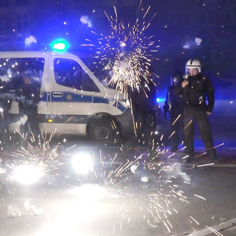 Polizeibeamte stehen hinter explodierendem Feuerwerk. (Foto: picture-alliance / Reportdienste, Picture Alliance)