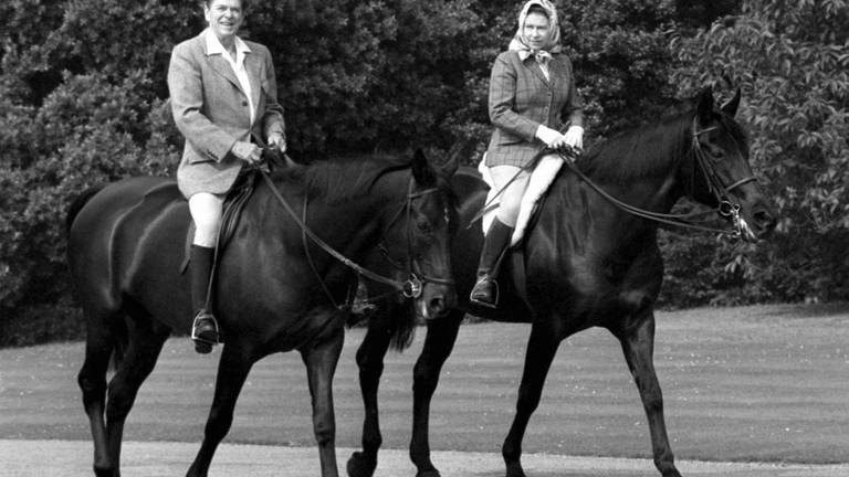 US-Präsident Ronald Reagan, der mit Königin Elisabeth II. im Windsor Home Park reitet.  (Foto: dpa Bildfunk, picture alliance/dpa/PA Wire | Pa)