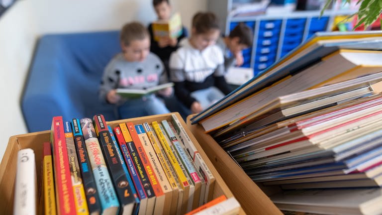 Kinder lesen in einer Grundschule. Bei der letzten Pisa-Studie haben Jungs beim Lesen wieder schlechter abgeschnitten als Mädchen. Forscher rätseln, woran das liegen könnte. Hamburger Wissenschaftler nennen nun Geschlechter-Klischees als einen möglichen Grund. Diese können positive oder negative Auswirkungen auf die Lesefreude der Kinder haben - und damit auf die Leseleistung.