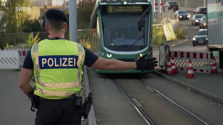Polizist hält Straßenbahn an