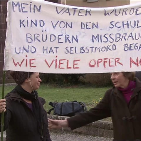 Zwei Frauen mit Plakat bei Demonstration