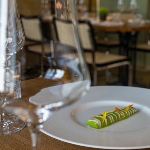 Eine nach Matjesart gebeizte Aubergine liegt im Sternerestaurant "bi:braud" auf einem Teller an einem leeren Tisch. (Foto: dpa Bildfunk, picture alliance/dpa | Stefan Puchner)
