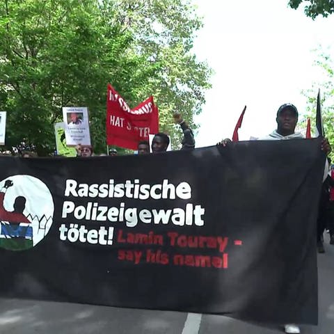 Demonstranten mit einem Banner gegen Polizeigewalt