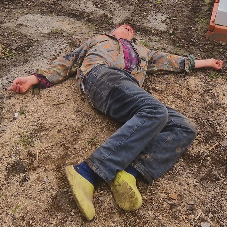 Ein Mann liegt zum Sterben in seinem Garten. (Foto: Akademie der Diözese Rottenburg-Stuttgart/Reiner Molt)