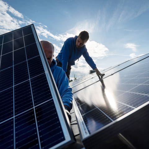 Zwei Männer arbeiten an einer Solaranlage auf einem Dach (Foto: dpa Bildfunk, picture alliance/dpa/Marijan Murat (Symbolbild))