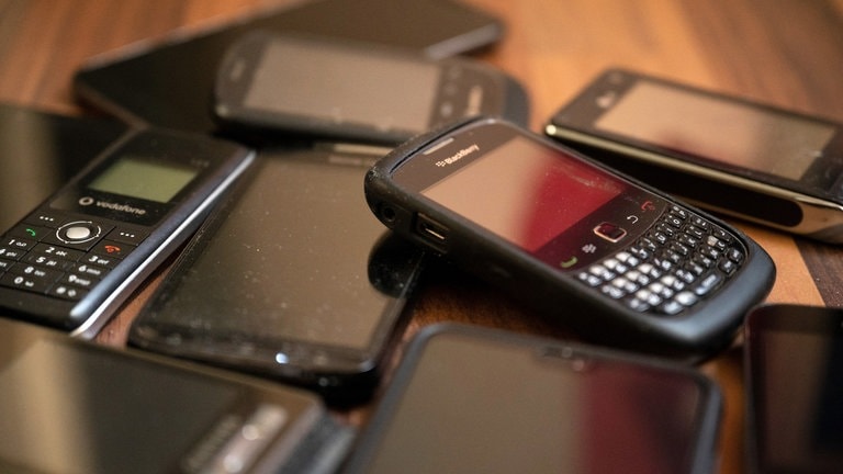 Ungenutzte Handys liegen auf dem Boden. Alte Elektrogeräte wie Rasierer oder Handys sollen Bürgerinnen und Bürger auch in Discountern und Supermärkten abgeben können. (Foto: dpa Bildfunk, picture alliance/dpa | Lisa Ducret)