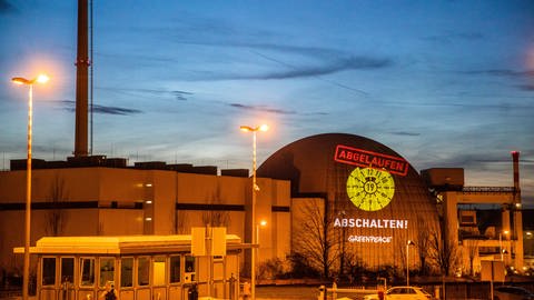 Mit Hilfe eines großen Projektors wurde symbolisch eine abgelaufene HU-Plakette an das Kernkraftwerk Neckarwestheim gebeamt. (Foto: picture-alliance / Reportdienste, picture alliance/dpa | Christoph Schmidt)