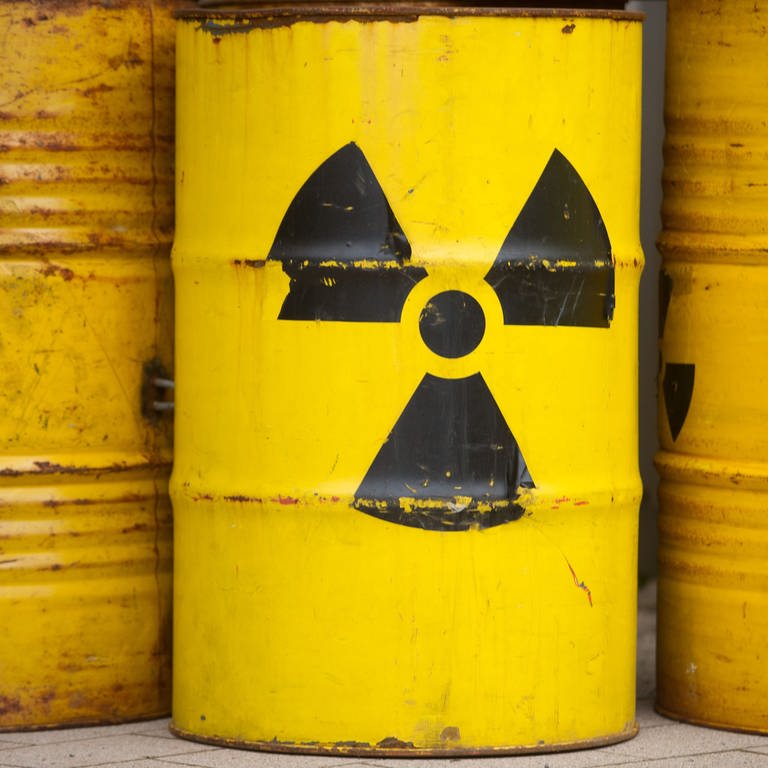 Gelbe Fässer mit Atommüll und dem Zeichen für Radioaktivität