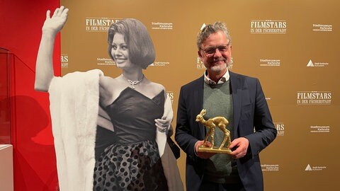 Oberbürgermeister Mentrup neben einem Bild von Sophia Loren in der Bambi-Ausstellung in Karlsruhe. (Foto: SWR) Oberbürgermeister Mentrup neben einem Bild von Sophia Loren in der Bambi-Ausstellung in Karlsruhe.