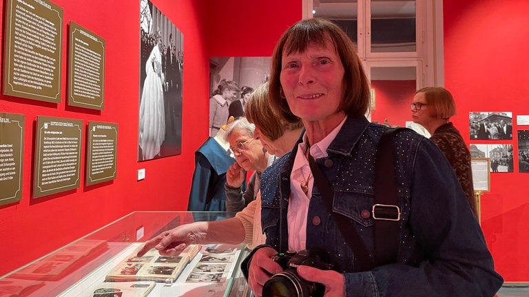Bambi-Ausstellung Karlsruhe: Silvia Brunn neben einer Vitrine mit ihren Autogrammkarten-Alben (Foto: SWR, Theresa Ehrl) Bambi-Ausstellung Karlsruhe: Silvia Brunn neben einer Vitrine mit ihren Autogrammkarten-Alben