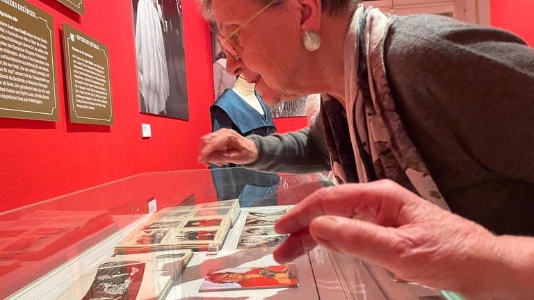 Besucherin der Bambi-Ausstellung in Karlsruhe schaut sich Fotos in einer Vitrine an. (Foto: SWR, Theres Ehrl) Besucherin der Bambi-Ausstellung in Karlsruhe schaut sich Fotos in einer Vitrine an.