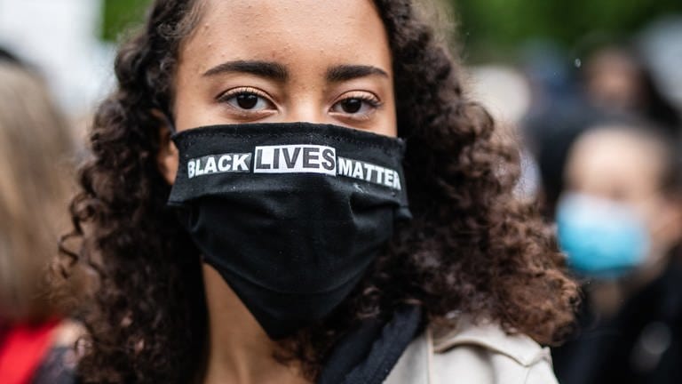 "Black Lives Matter" steht auf dem Mundschutz einer Teilnehmerin der Stuttgarter «Silent Demo» gegen Rassismus und Polizeigewalt im Oberen Schlossgarten geschrieben.