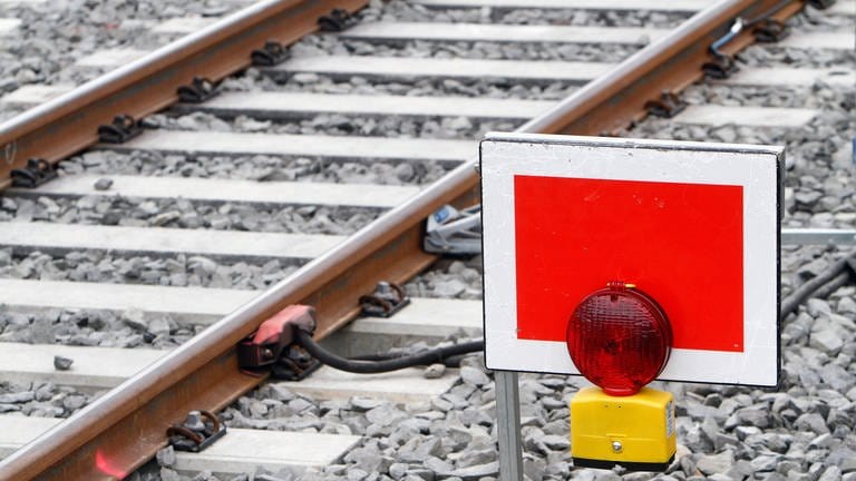 Ein rotes Stoppschild für Züge an einem Bahngleis