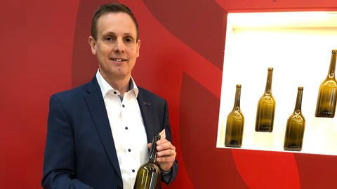 Werner Bender, Vorstand der Wein-Mehrweg eG, präsentiert auf der Fachmesse "ProWein" die neue Pfandflasche für Wein in der 0,75 Liter-Größe. (Foto: SWR, Dominik Bartoschek)