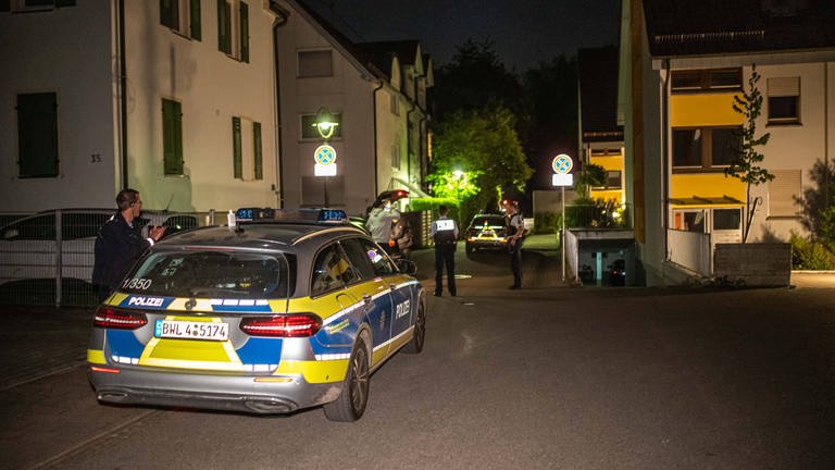 Ein Polizeiauto steht nach einem Tötungsdelikt bei Dämmerung vor einem Wohnhaus in Nürtingen (Foto: 7aktuell)