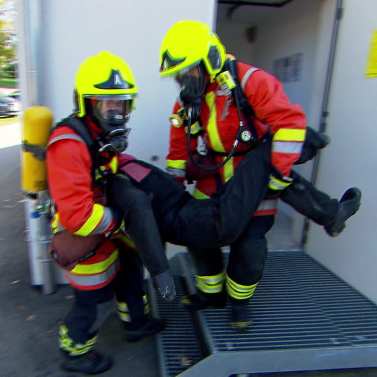 Zwei Feuerwehrleute der Freiwililligen Feuerwehr Aspach im Rems-Murr-Kreis üben mit Atemschutzgeräten die Rettung eines Opfers.