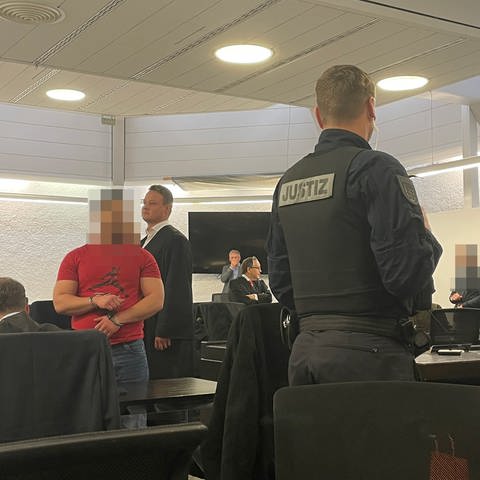 Mehrere Angeklagte stehen im Saal des Stuttgarter Landgerichts und warten auf die Urteilsverkündung. (Foto: SWR, Laura Cloppenburg)