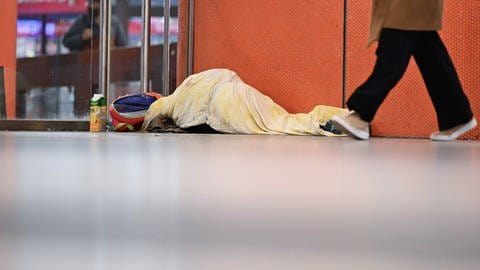 In der Stuttgarter Klett-Passage schläft eine obdachlose Person in einem Schlafsack.