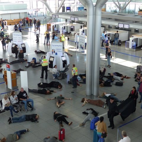 Teilnehmer einer Klimaschutz-Demo liegen im Terminal 3 des Stuttgarter Flughafens auf dem Boden.